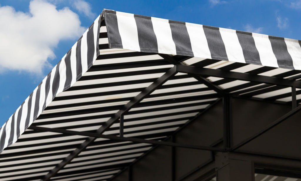 black and white striped awning with blue sky.